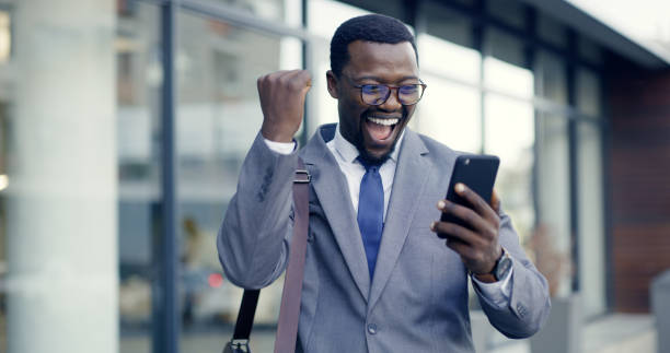 City businessman, celebration and phone success for surprise winner news, trading sales and happy fist announcement. Excited executive reading mobile notification, bonus deal and winning stock profit empresario de la ciudad, celebración y éxito telefónico para noticias sorpresa de ganadores, ventas comerciales y feliz anuncio de puño. ejecutivo emocionado leyendo notificaciones móviles, acuerdo de bonificación y ganancias de acciones ganadoras