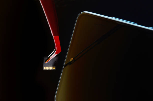 istock turned off smartphone and micro sd card pulled out of it with tweezers. 1430342901
