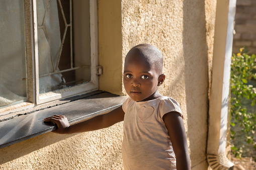 African girl standing in front of the house in the township