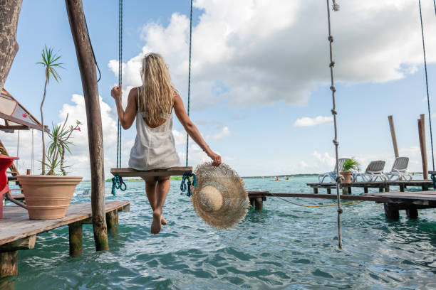 istock Woman sitting on a swing at a lagoon 1430343074