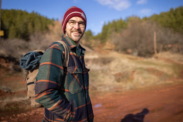 A portrait of a young adult man on a hiking trip in a forest