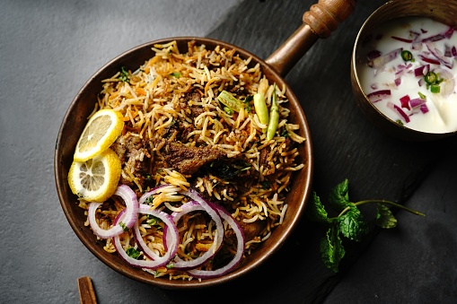 Hyderabadi Mutton goat biryani served with yogurt raita on moody setting