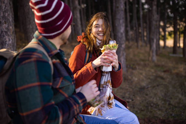 istock Young couple resting and eating on a hiking trip 1430345873