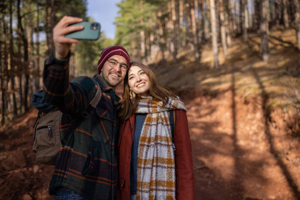 istock Young couple taking a selfie while on a forest hiking trip 1430346282