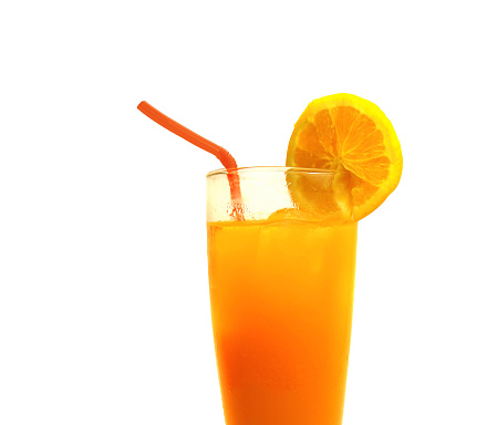 Front view of orange fruit and glass of orange juice on black background.