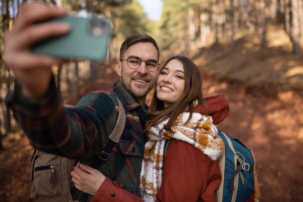 istock Young couple taking a selfie while on a forest hiking trip 1430346661