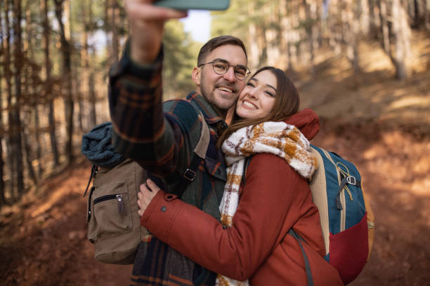 istock Young couple taking a selfie while on a forest hiking trip 1430346669