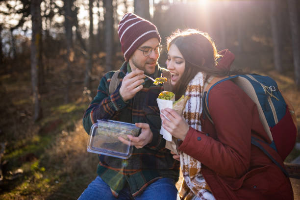 istock Young couple resting and eating on a hiking trip 1430346856
