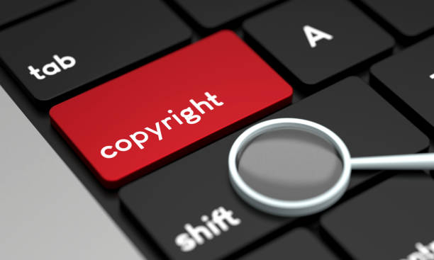 istock Close-Up Laptop Keyboard With Copyright Button and magnifying glass 1430346937