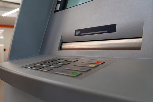 Close-up of the laviature of a modern ATM in a shopping center. Selective focus