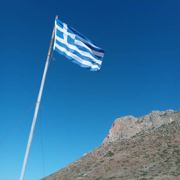 istock Greek flag flying against blue sky 1430353105