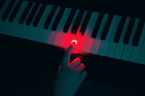 Female hand pressing piano key in the dark Female hand pressing piano key in the dark italian music stock pictures, royalty-free photos & images
