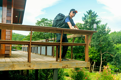 Backpackers capture the beauty of nature standing on a hillside wooden terrace.