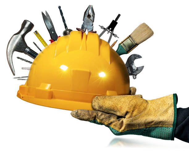 main gantée tenant un casque de sécurité jaune avec des outils de travail - adjustable wrench wrench orange hand tool photos et images de collection