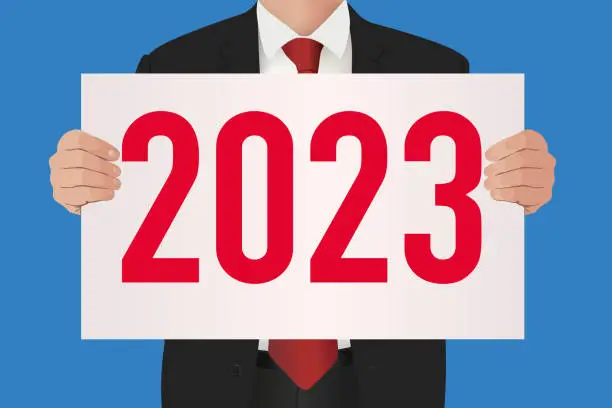 Vector illustration of The year 2023 written on a white sign held by a businessman in a suit.