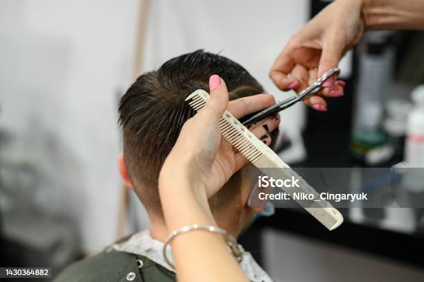 A Teenager In A Beauty Salon Gets A Haircut A Hairdresser Cuts A Teenage Boys Hair Stock Photo - Download Image Now
