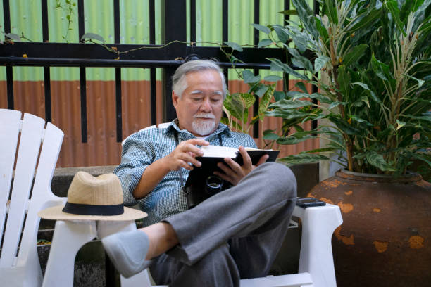 Senior man is sitting in the garden. Spending time for leisure activity. Active senior concept.