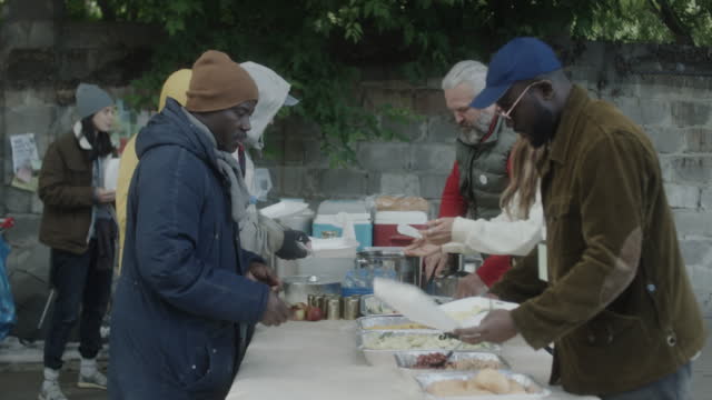 Volunteers Giving Food to Homeless People