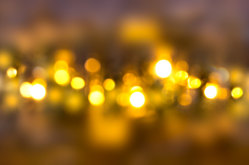 Blurred lights of bulbs on dark background. Defocused. Christmas, New Year, holiday