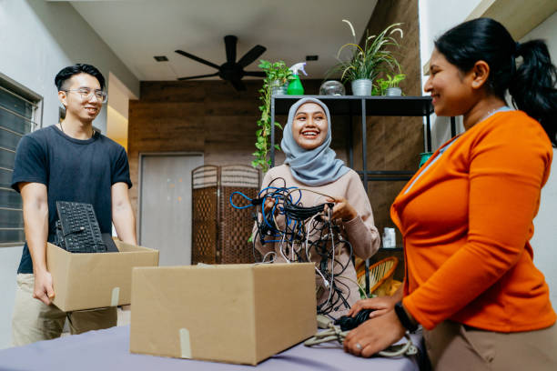 Image of a group of multiracial asian people managing computer parts and cables for recycle. Asian people recycling electronic waste.