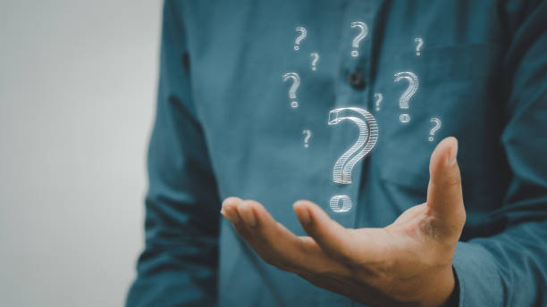 istock business man icon questions marks on virtual screen at interrogation. 1430373235