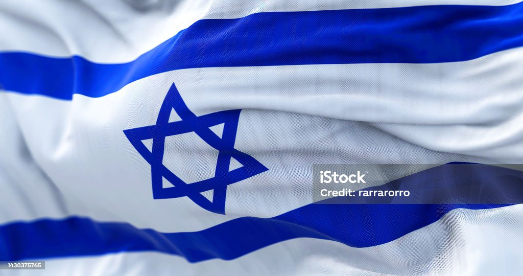 Close-up view of the Israel national flag waving in the wind Close-up view of the Israel national flag waving in the wind. The State of Israel is a State of the Near East facing the Mediterranean Sea. Fabric textured background. Selective focus Israeli Flag Stock Photo