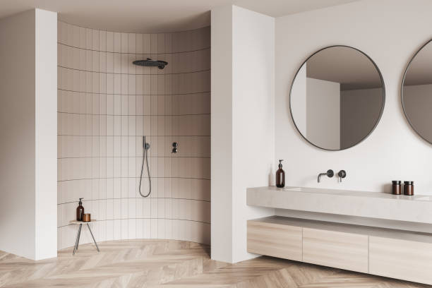 istock Corner view on bright bathroom interior with large round mirrors, 1430376471