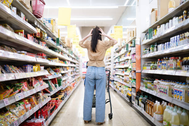 Woman worried at the grocery store Woman worried at the grocery store stereotypical housewife stock pictures, royalty-free photos & images