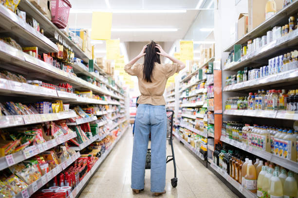 woman worried at the grocery store - asian ethnicity shopping mall supermarket store imagens e fotografias de stock