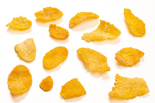 Macrophotography of corn flakes on white background.