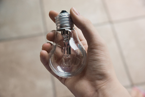 Female hand holding lightbulb
