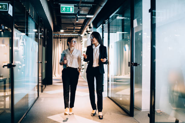istock Confident Caucasian colleagues 30s enjoying friendship relations in office workspace, successful female executive managers walking in corporate hallway and discussing business ideas for cooperate 1430381982
