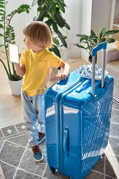 istock A sad child using a mobile phone and waiting for departure. Family relocation, flight from the country 1430385458