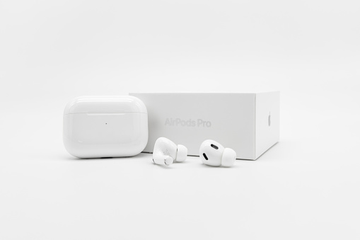Germany – October 02, 2022: Product shot of Apple AirPods Pro 2nd generation next to the charging case and packaging box on a white background.