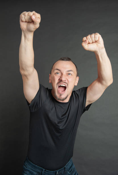 Young handsome screaming man with hands raised up protest gesture stock photo