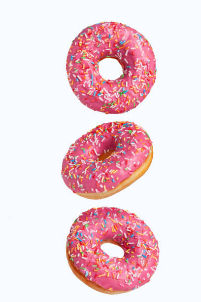 istock Three sweet donuts with pink icing are flying in the air. 1430392376