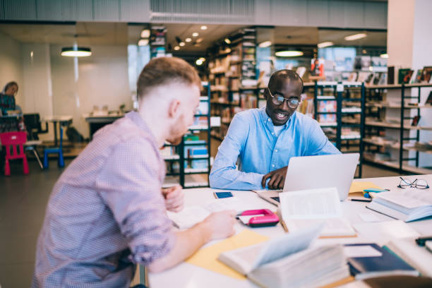 istock Male students studying together in library 1430394132