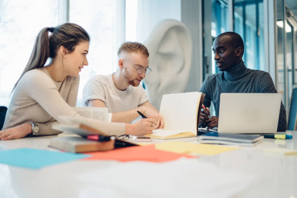 istock Concentrated multiracial students doing research together in library 1430394247