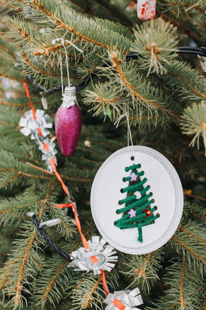 istock Painted electric light bulb and plastic cup on Christmas tree. DIY decoration 1430397791