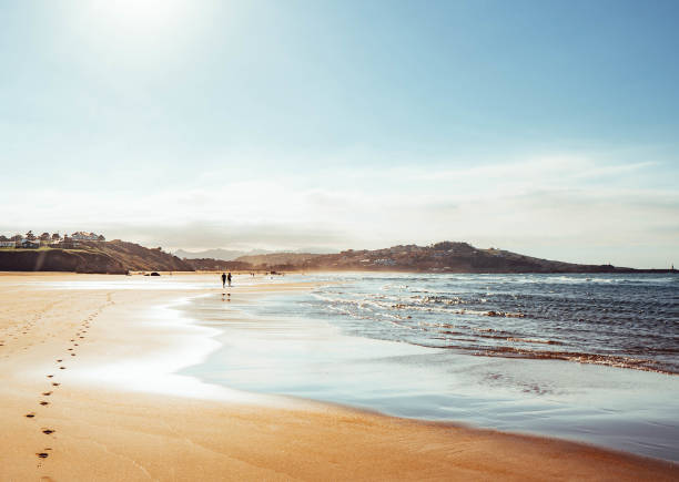 istock two people walking on the beach at sunset 1430398849
