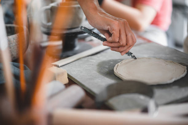 istock View of female hands works with clay makes future ceramic plate, ceramic artist makes classes of hand building in modern pottery workshop, creative people handcrafted design 1430398893