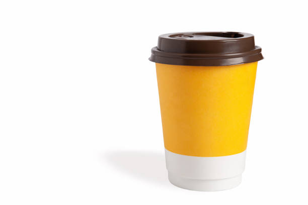 Blank yellow takeaway cup of coffee with a brown lid. Isolated on white background. Copy space, close-up