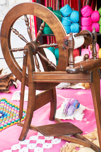 istock Antique wooden spinning wheel with colored wool bobbins 1430410178