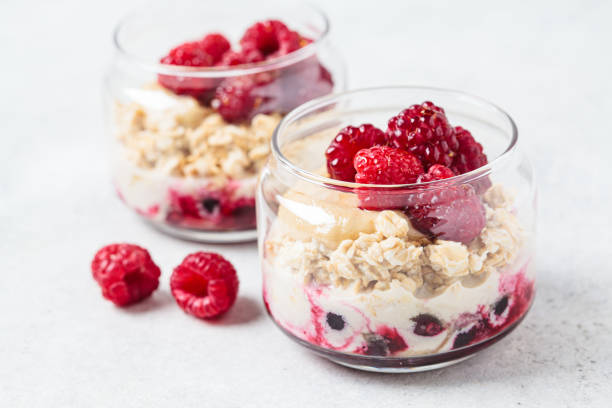 Overnight oatmeal with raspberries, currants and tahini in jar. Breakfast concept. stock photo