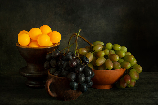 Still life with ripe grapes and orange balls