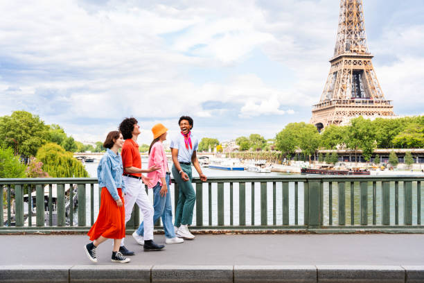 Group of young happy friends visiting Paris and Eiffel Tower, Trocadero area and Seine river - Multicultural group of tourists sightseeing the France capital city