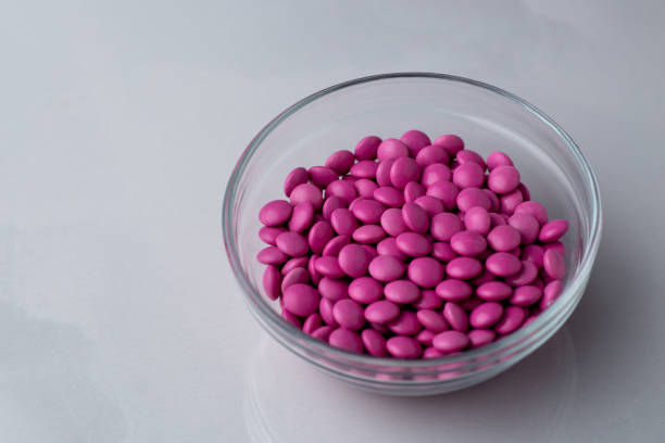 istock Pink candy coated chocolate button sprinkles in a bowl on bright marble - M&Ms, Smarties, sprinkles 1430418211