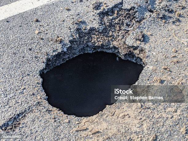 Deep Sink Hole Opened Up In A Tarmac Road Surface Stock Photo - Download Image Now - Sinkhole, Pot Hole, UK