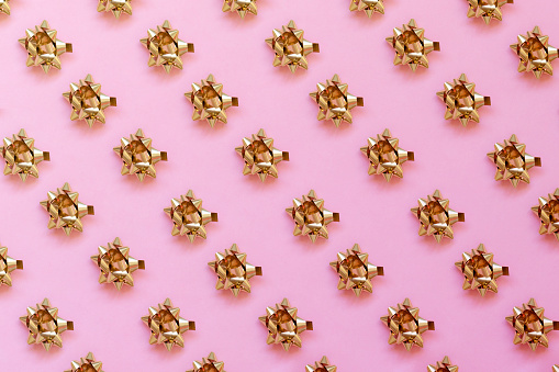 Gold Colored  Bow on a Pink Background