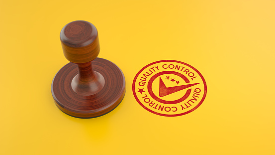 Wooden Quality Control Stamp on Yellow Background